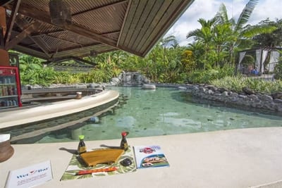 Swim-up sushi and pool bar with a sushi board and menus set out beside the hot-spring pool at Arenal Springs Resort, La Fortuna, Costa Rica