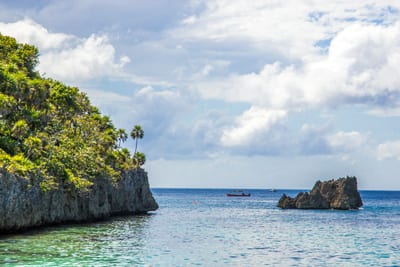 A boat anchored in clear turquoise shallows off West Bay, Roatán, Bay Islands, Honduras