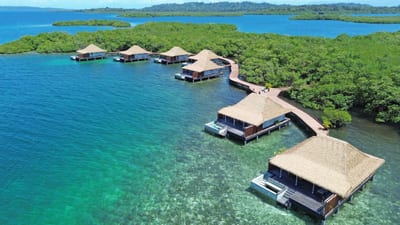 Aerial overwater villas beside a jungle island, Bocas del Toro, Panama.