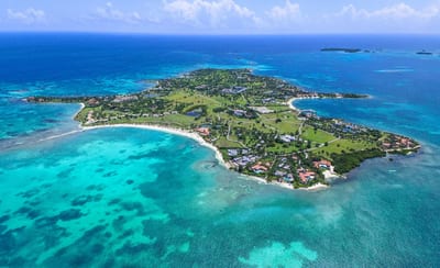 A private island set in turquoise Caribbean water, from the air.