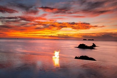 Flame water feature rising from the infinity pool against a fiery Pacific sunset at Casa Chameleon in Las Catalinas, Guanacaste, Costa Rica