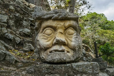 A carved stone face on a Maya stela at Copán, the UNESCO World Heritage archaeological park, Honduras