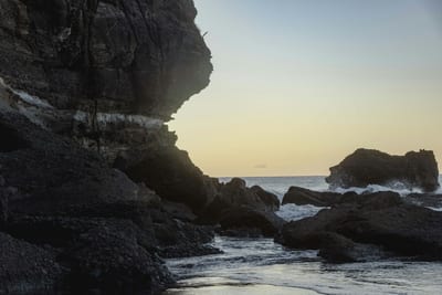 A secluded rocky cove at golden hour on the El Salvador coast