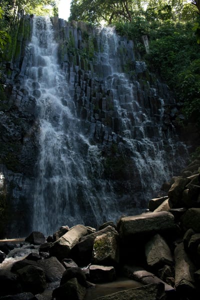 A jungle waterfall cascading into a natural pool in El Salvador