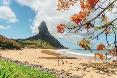 The Dois Irmãos peaks rise over a beach on Fernando de Noronha, Brazil.