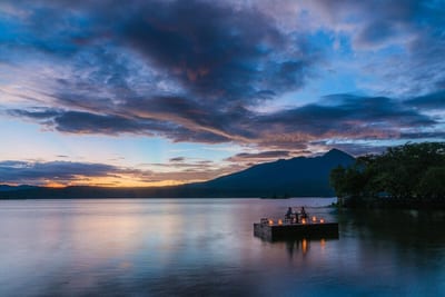 The dock of the Jícaro Island ecolodge reaching over calm Lake Nicaragua toward Mombacho volcano among the Granada isletas, Nicaragua.