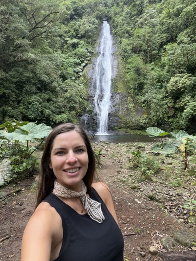 Melanie Marsell, co-founder of Explore the Americas, in front of a waterfall on the El Silencio Lodge reserve hike