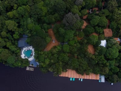 Aerial view of the turtle-shaped pool and rainforest bungalows of Pachira Lodge beside the canal in Tortuguero, Costa Rica