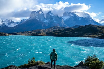 A hiker on a ridge looks out over the peaks of Chilean Patagonia.