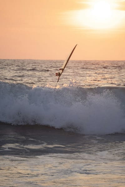 A surfer in the waves at sunset off Puerto Escondido, Oaxaca, Mexico.
