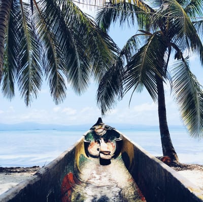 A dugout canoe floats on the turquoise water of the San Blas Islands, Guna Yala, Panama.