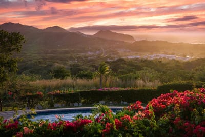 The crescent bay and white-sand beach of San Juan del Sur framed by green Pacific headlands on the southern Nicaraguan coast.