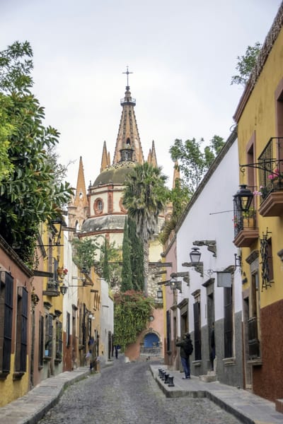 A colorful colonial street leads to La Parroquia in San Miguel de Allende, Mexico.