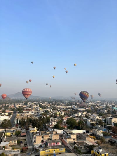 Hot-air balloons drifting over the Pyramid of the Sun and the valley of Teotihuacán near Mexico City at sunrise, Mexico.