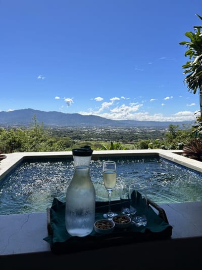 Tray of sparkling wine and snacks on the edge of a private plunge pool at Xandari Resort, overlooking the Central Valley and mountains near San José, Costa Rica