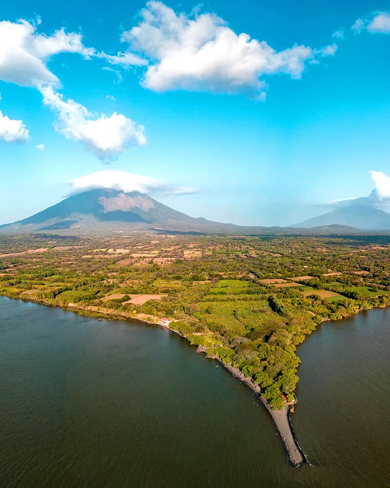 A dramatic view of Ometepe Island with its twin volcanoes, Concepción and Maderas, rising from Lake Nicaragua under a vivid sky.