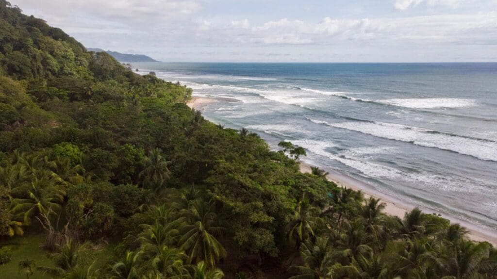 Santa Teresa beach aerial view, Costa Rica coastline with jungle and ocean waves.